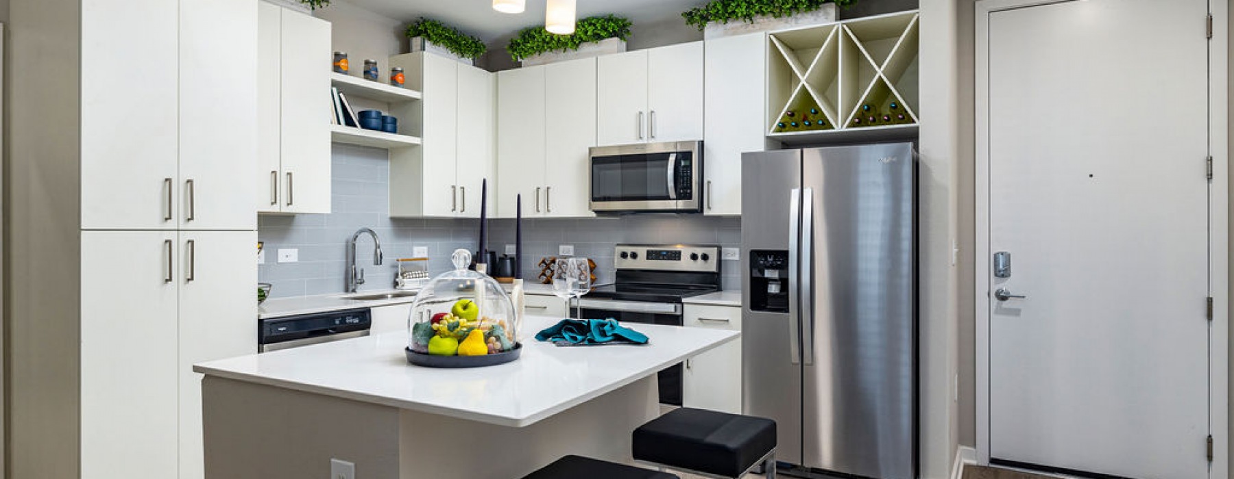 Jade at North Hyde Park Apartments kitchen with stainless steel appliances, modern cabinetry, pendant lighting, island kitchen