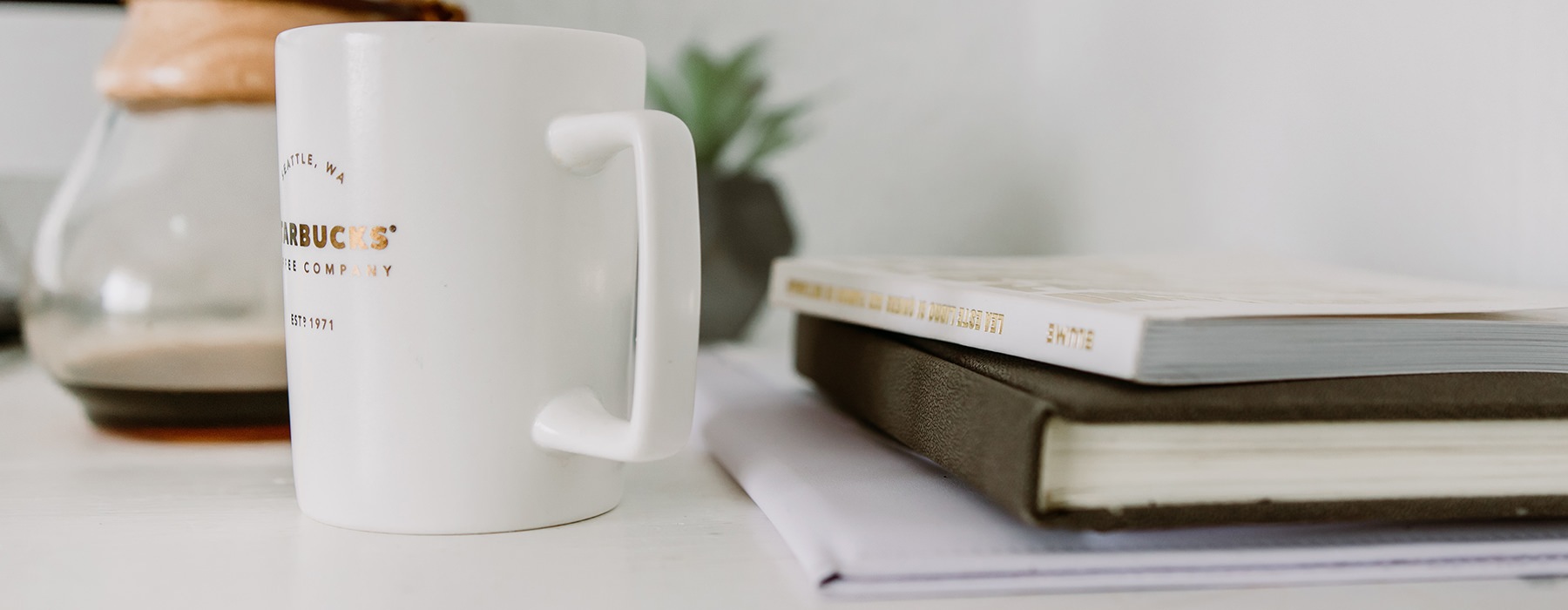 Coffee cup and books sitting on a modern table 